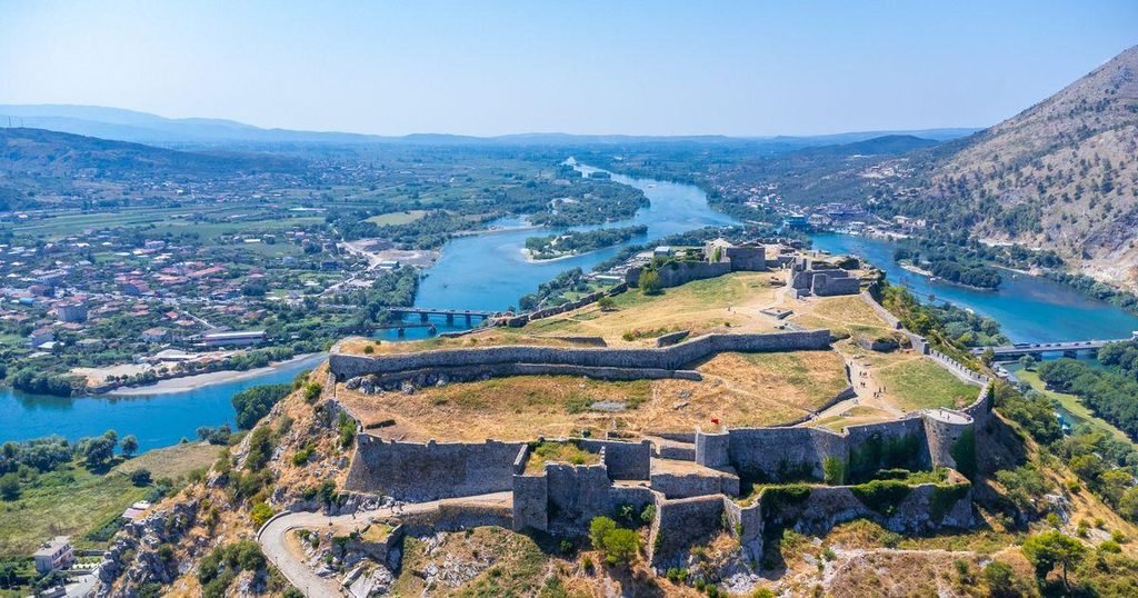 Historic stone walls of Rozafa Castle in Shkoder, Albania, with an Albanian flag
