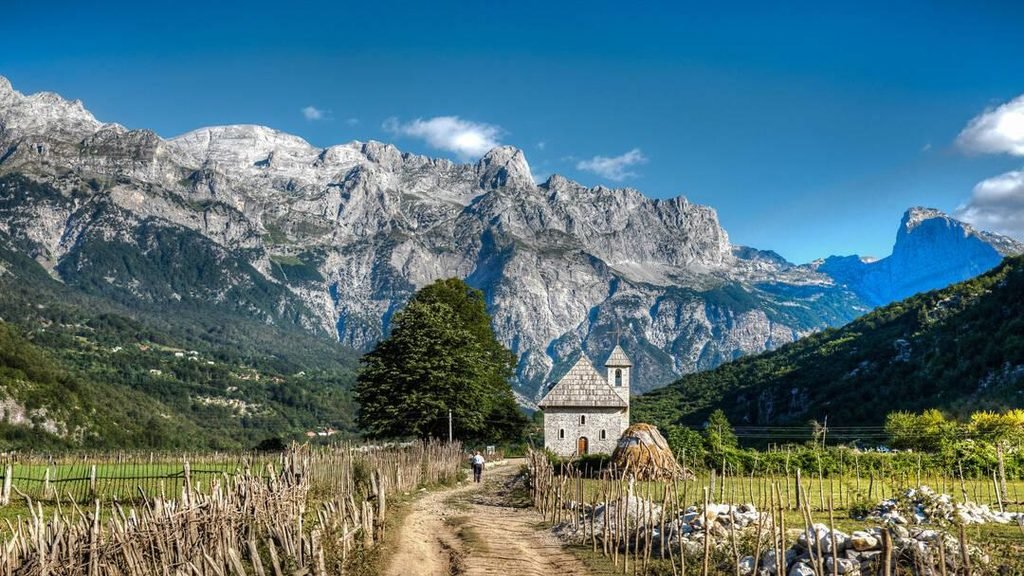 Historic church in Theth village surrounded by the mountains of the Albanian Alps